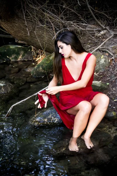 Belle femme sur la rive d'une rivière de montagne portant un eveni — Photo