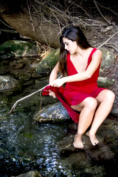 クラッチを着て山川のほとりの美しい女性 — ストック写真