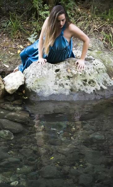 Όμορφη γυναίκα στην όχθη ενός ποταμού στο βουνό με μια βραδιά — Φωτογραφία Αρχείου
