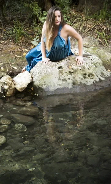 Hermosa mujer en la orilla de un río de montaña con una noche — Foto de Stock