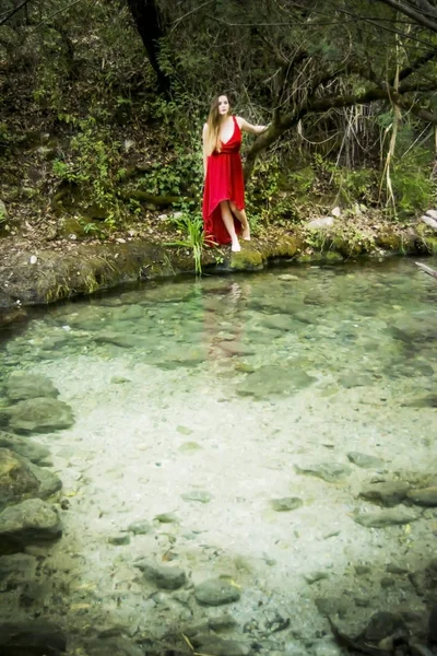 Mooie vrouw aan de oever van een rivier berg met een avond — Stockfoto