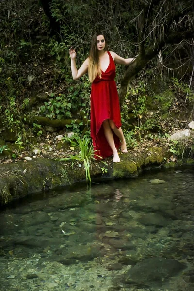 Hermosa mujer en la orilla de un río de montaña con una noche — Foto de Stock