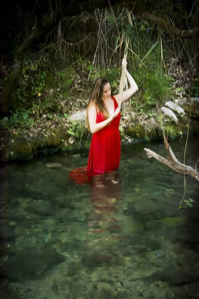 Mooie vrouw aan de oever van een rivier berg met een avond — Stockfoto