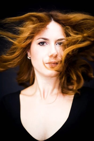 Saçları siyah backgrou sallayarak güzel bir kadın portresi — Stok fotoğraf