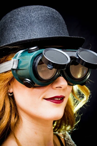 Portrait of a beautiful woman with special glasses and hat on bl — Stock Photo, Image