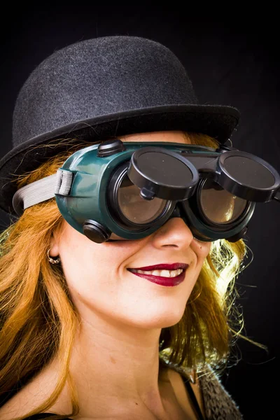 Portrait of a beautiful woman with special glasses and hat on bl — Stock Photo, Image