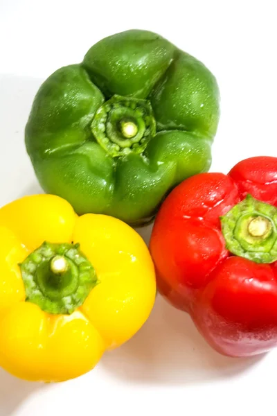 Pimentos amarelos, verdes e vermelhos isolados sobre fundo branco — Fotografia de Stock