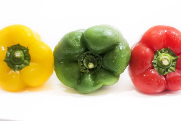 Pimentos amarelos, verdes e vermelhos isolados sobre fundo branco — Fotografia de Stock