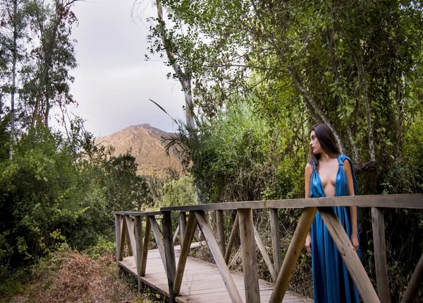 Belle femme sur le terrain sur un pont en bois portant un eveni — Photo