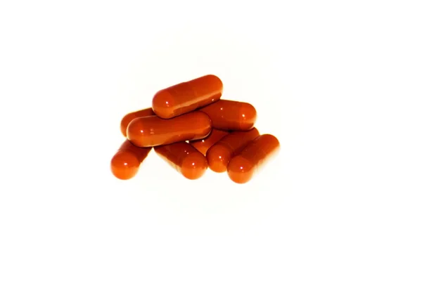 Muitas pílulas vermelhas no fundo branco — Fotografia de Stock