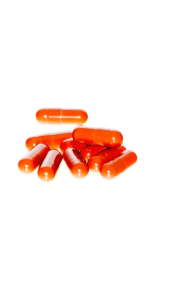 Beaucoup de pilules rouges sur fond blanc — Photo