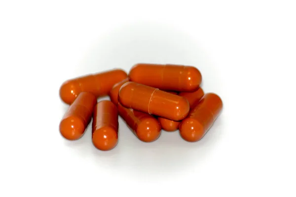 Un montón de píldoras rojas sobre fondo blanco —  Fotos de Stock