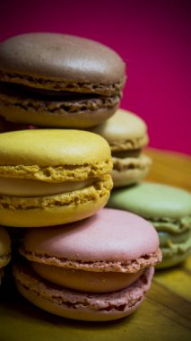 Ahşap tabakta izole edilmiş renkli makaronlar, tipik Fransız yemekleri.