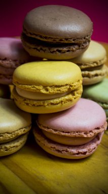 Ahşap tabakta izole edilmiş renkli makaronlar, tipik Fransız yemekleri.