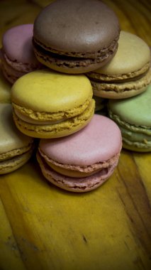 Ahşap tabakta izole edilmiş renkli makaronlar, tipik Fransız yemekleri.