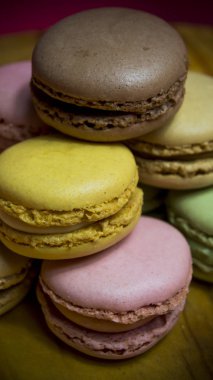 Ahşap tabakta izole edilmiş renkli makaronlar, tipik Fransız yemekleri.