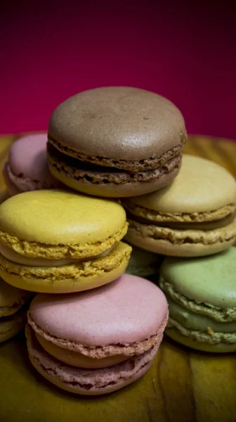 Colored macarons isolated on wooden dish, typical French dish