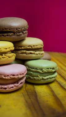 Ahşap tabakta izole edilmiş renkli makaronlar, tipik Fransız yemekleri.