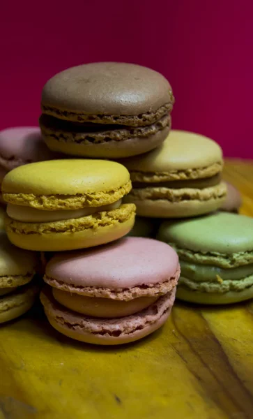 Colored macarons isolated on wooden dish, typical French dish