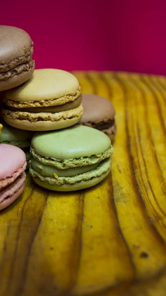 Colored macarons isolated on wooden dish, typical French dish