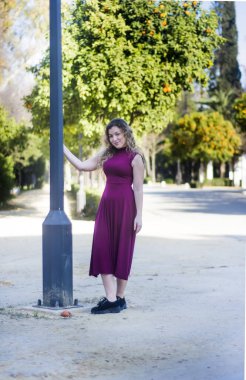 Parkın fenerine yaslanmış güzel bir kadın.