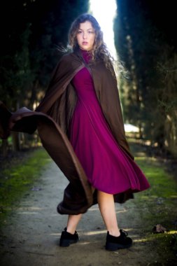 Ormanda bir patikada pelerinli güzel kadın