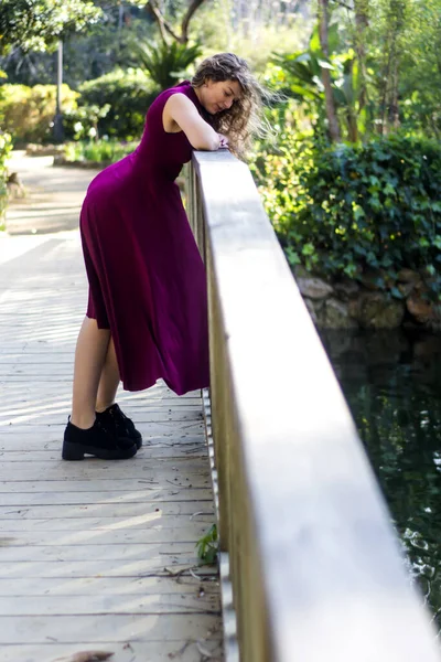 晴れた日に公園の木製の橋の上に美しい女性 — ストック写真