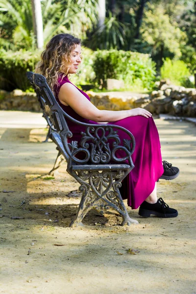 美丽的女人坐在公园的长椅上 — 图库照片