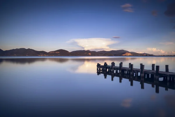 木製の桟橋か突堤に青い湖の夕日と空の反射 — ストック写真