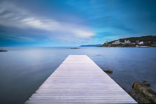 Bahía de Castiglioncello muelle de madera, rocas y mar al atardecer. Toscana —  Fotos de Stock