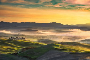 Volterra sisli panorama sunse üzerinde inişli çıkışlı tepeler ve yeşil alanları,
