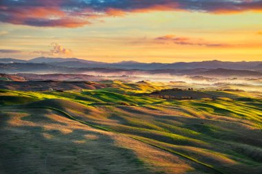 Volterra sisli panorama sunse üzerinde inişli çıkışlı tepeler ve yeşil alanları,