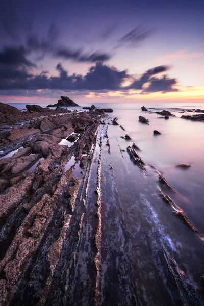 Bir deniz günbatımı üzerinde kayalarda. Tuscany sahil. İtalya — Stok fotoğraf