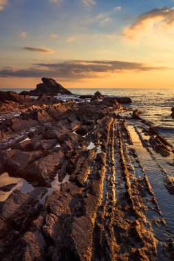 Bir deniz günbatımı üzerinde kayalarda. Tuscany sahil. İtalya