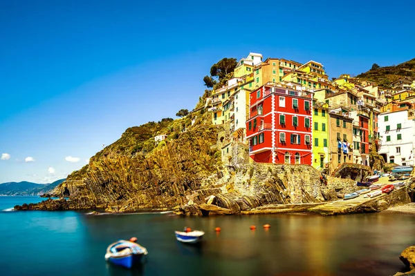 Riomaggiore pueblo, rocas y el mar al atardecer. Cinque Terre, Ligu — Foto de Stock