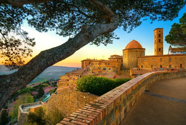 Toscana, ciudad de Volterra skyline, iglesia y árboles en la puesta del sol. Ital — Foto de Stock