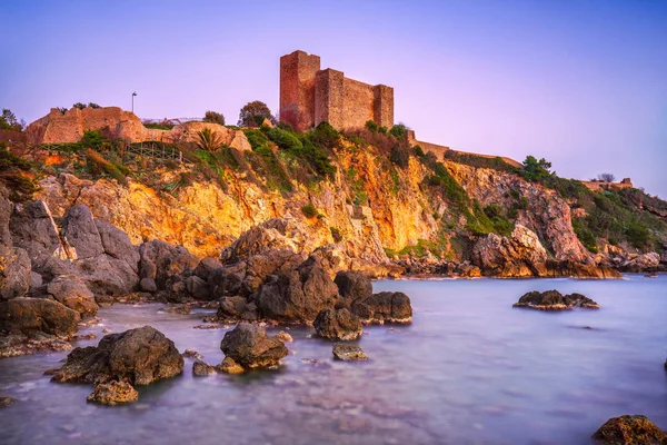 Spiaggia rocciosa di Talamone e fortezza medievale al tramonto. Maremma Arg — Foto Stock