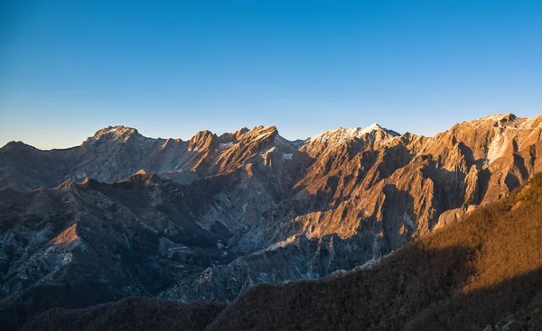 Apuane alpi montagnes enneigées et carrière de marbre au coucher du soleil en hiver — Photo