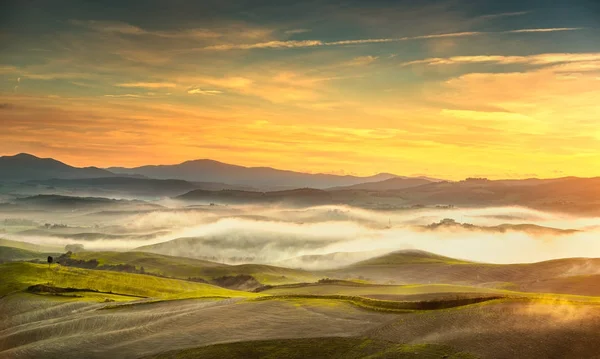 Panorama nebuloso de Volterra, colinas ondulantes e campos verdes no sol — Fotografia de Stock