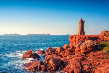 Ploumanach lighthouse sunset in pink granite coast, Brittany, Fr clipart