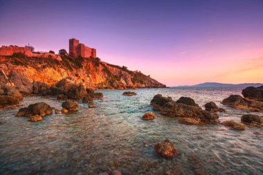 Talamone kaya Plajı ve gün batımında ortaçağ kalesi. Maremma Arg
