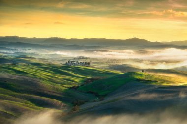 Volterra sisli panorama sunse üzerinde inişli çıkışlı tepeler ve yeşil alanları,