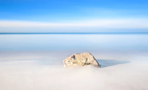 Kayanın üzerinde bir beyaz kum plaj ve deniz ufukta. — Stok fotoğraf