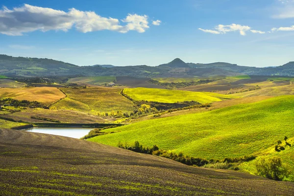 Volterra panorama, rolling hills, green fields and small lake. T — Stock Photo, Image