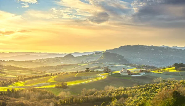 Volterra panorama, κυλιόμενοι λόφοι, πράσινα λιβάδια και λευκός δρόμος. Τ — Φωτογραφία Αρχείου