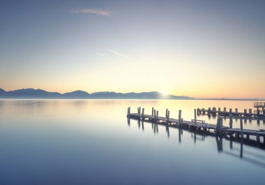Güneşin doğuşunda üç tahta iskele ya da jettie. Torre del Lago Puccini