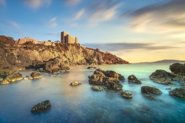 Talamone kayalık plajı ve ortaçağ kalesi Rocca Aldobrandesca ve günbatımında duvarlar. Maremma Argentario İtalyan seyahat yeri. Toskana, İtalya.