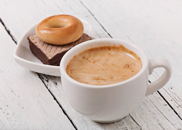 Xícara de café e deliciosos biscoitos assados no fundo de madeira velha . — Fotografia de Stock