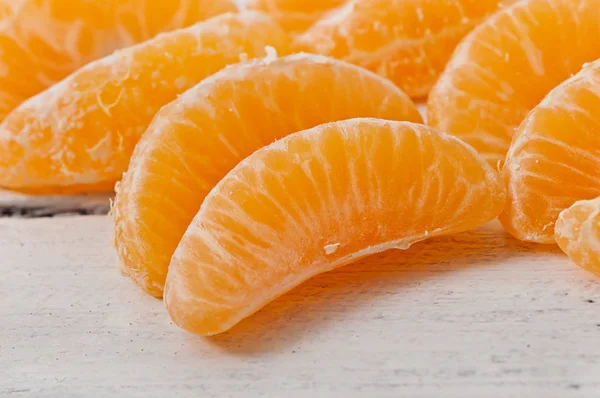 Fette di mandarino su uno sfondo di legno, frutto . — Foto Stock