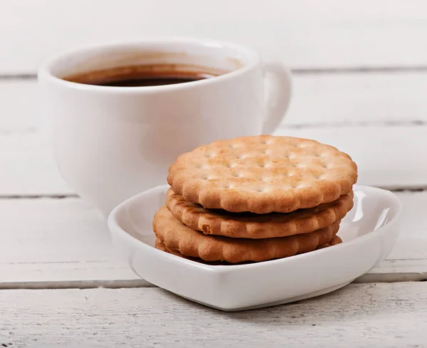 Cup of coffee and delicious baked cookies on old wooden background. — Stock Photo, Image